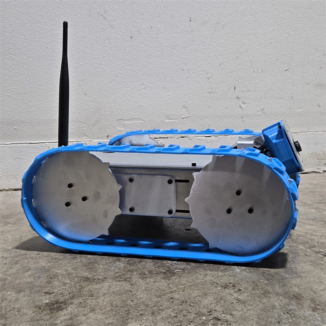 Side profile of the Gopher tracked inspection robot showing blue tracks and low ground clearance